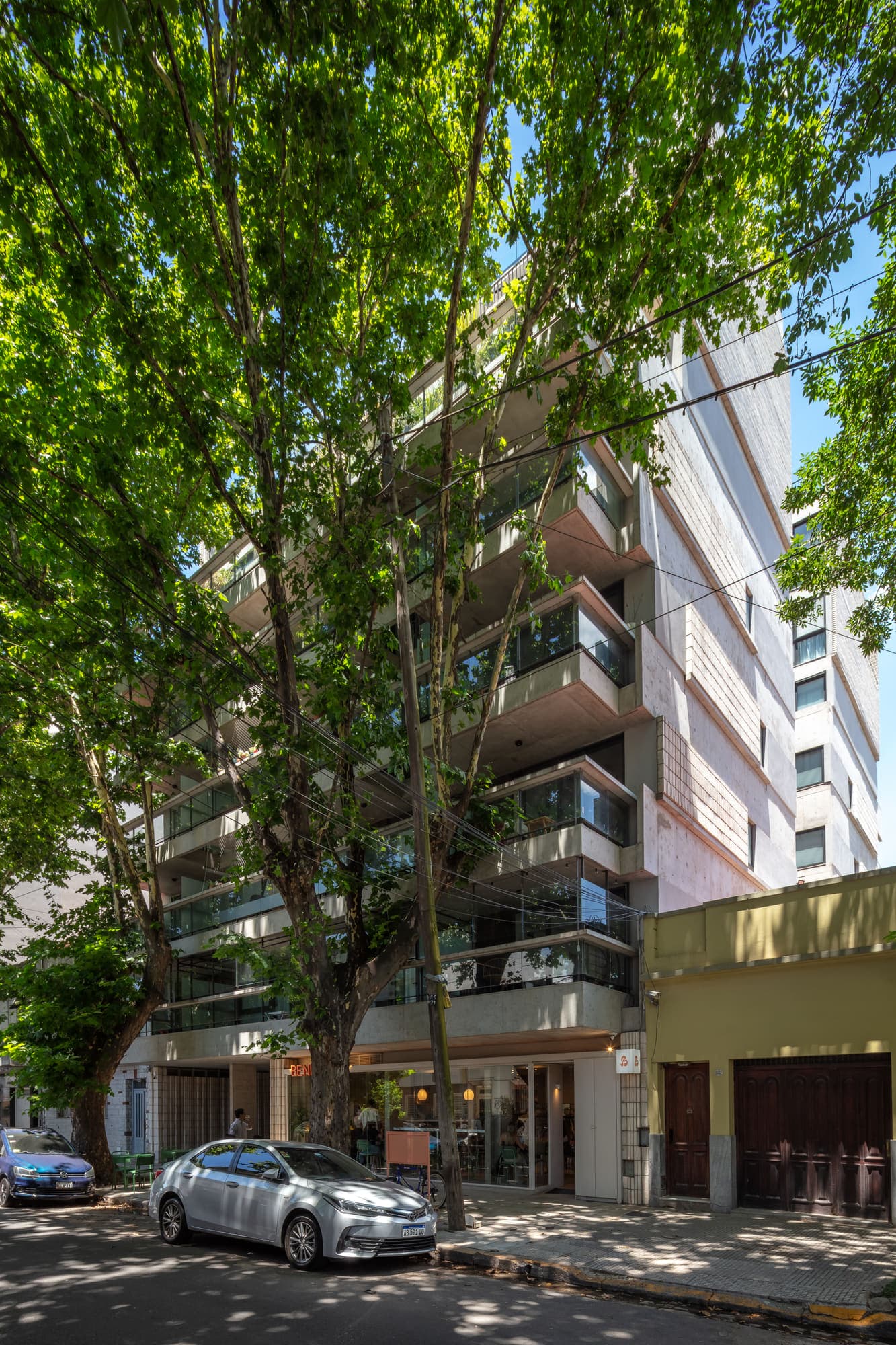 Fachada del Proyecto Giribone entre los árboles de la calle